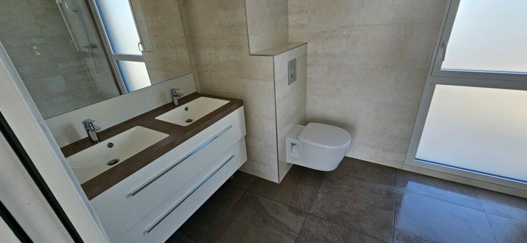 Salle de bain nettoyée : double vasque, miroir et WC suspendu