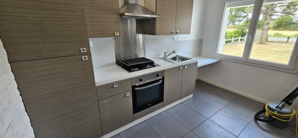 Cuisine nettoyée lors d'une remise en état : four, plaques, évier et placards